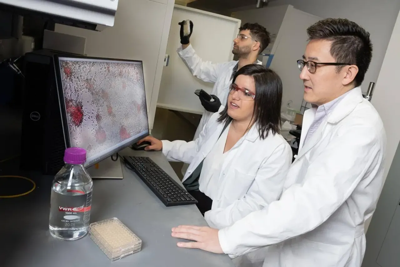 group of researchers wearing white lab coats while working in a lab